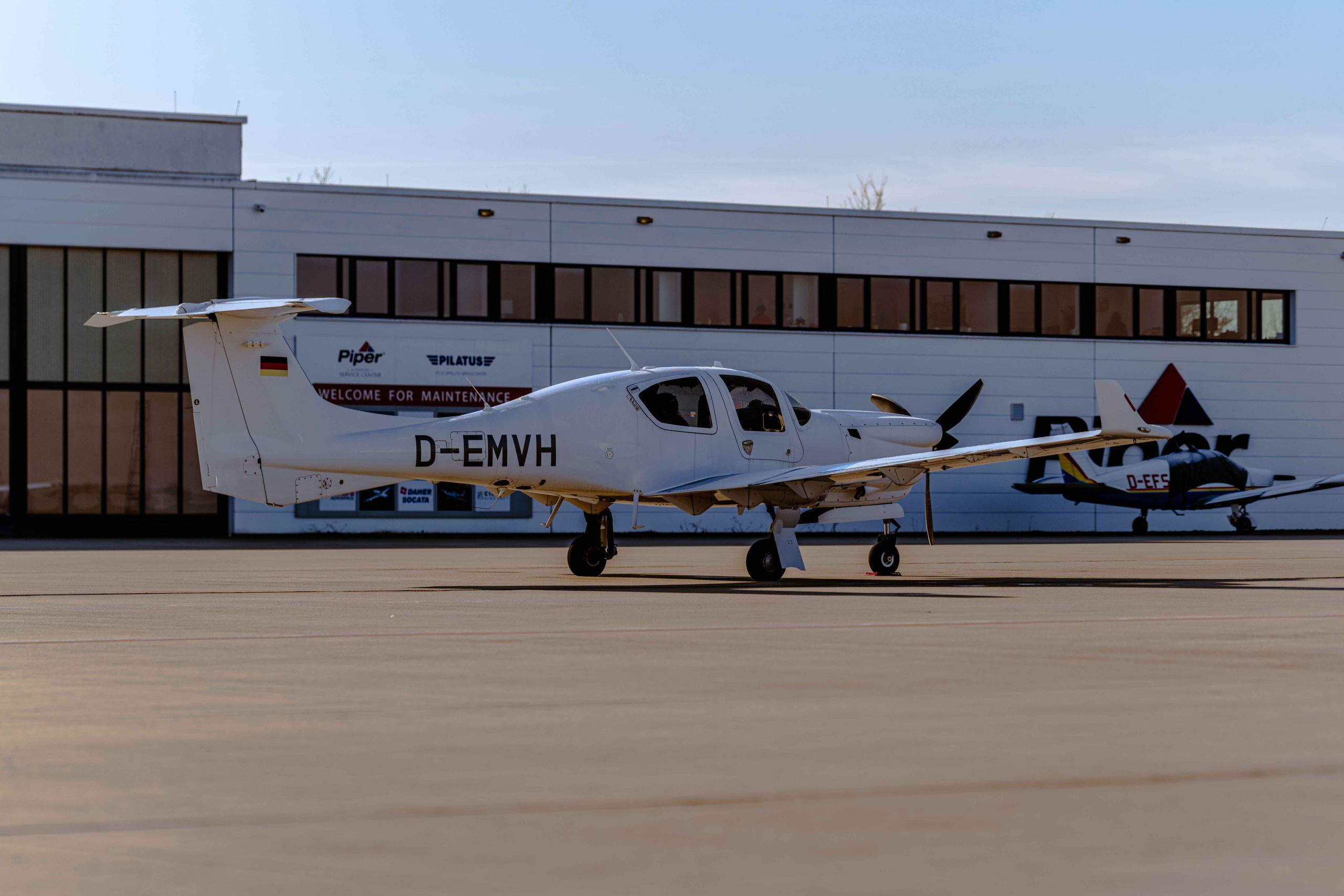 Diamond DA50 RG einmotoriges Reiseflugzeug auf dem Vorfeld eines Flughafens – modernes Design mit Einziehfahrwerk und effizienter Reiseperformance.