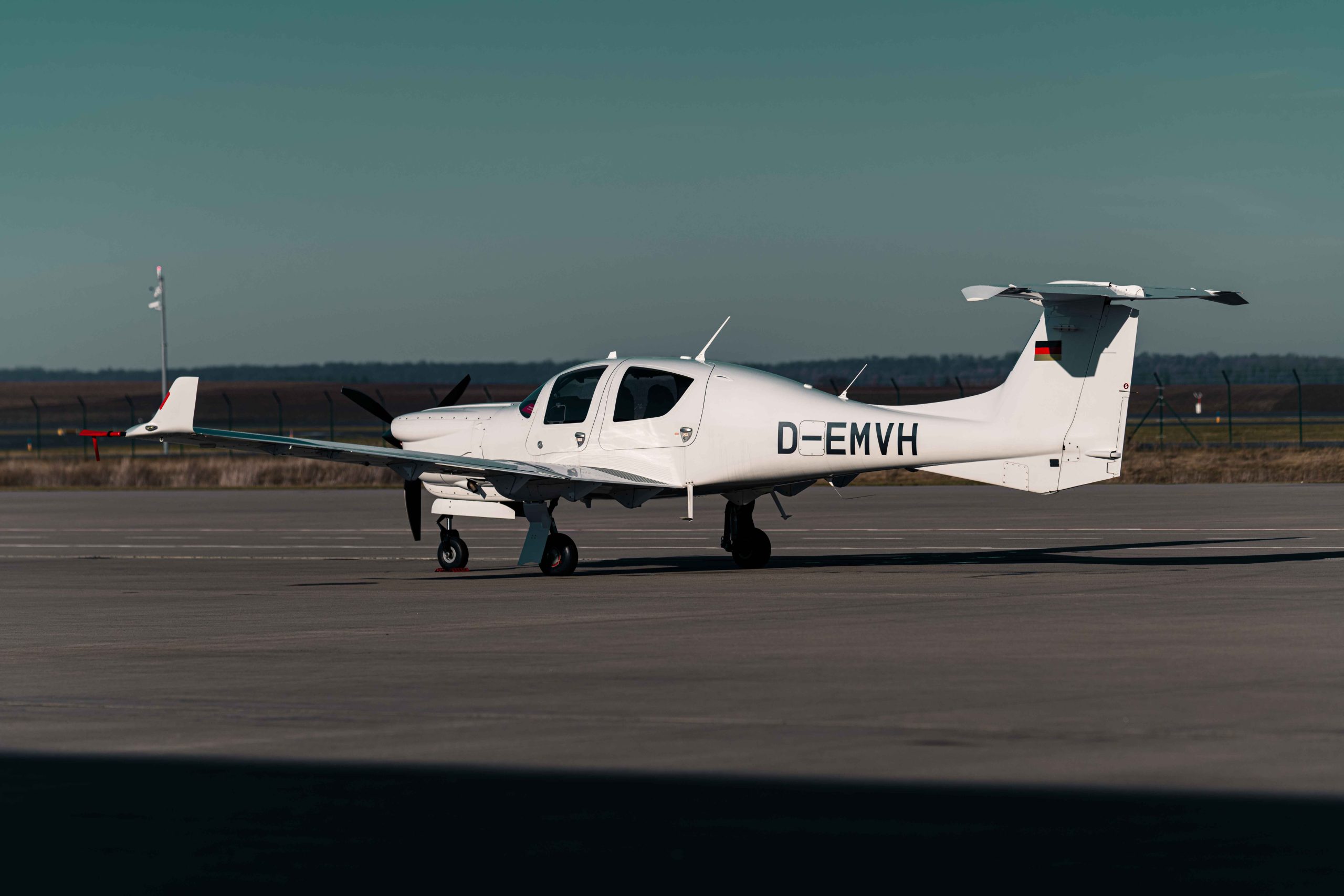 Diamond DA50 RG einmotoriges Reiseflugzeug auf dem Vorfeld eines Flughafens – modernes Design mit Einziehfahrwerk und effizienter Reiseperformance.