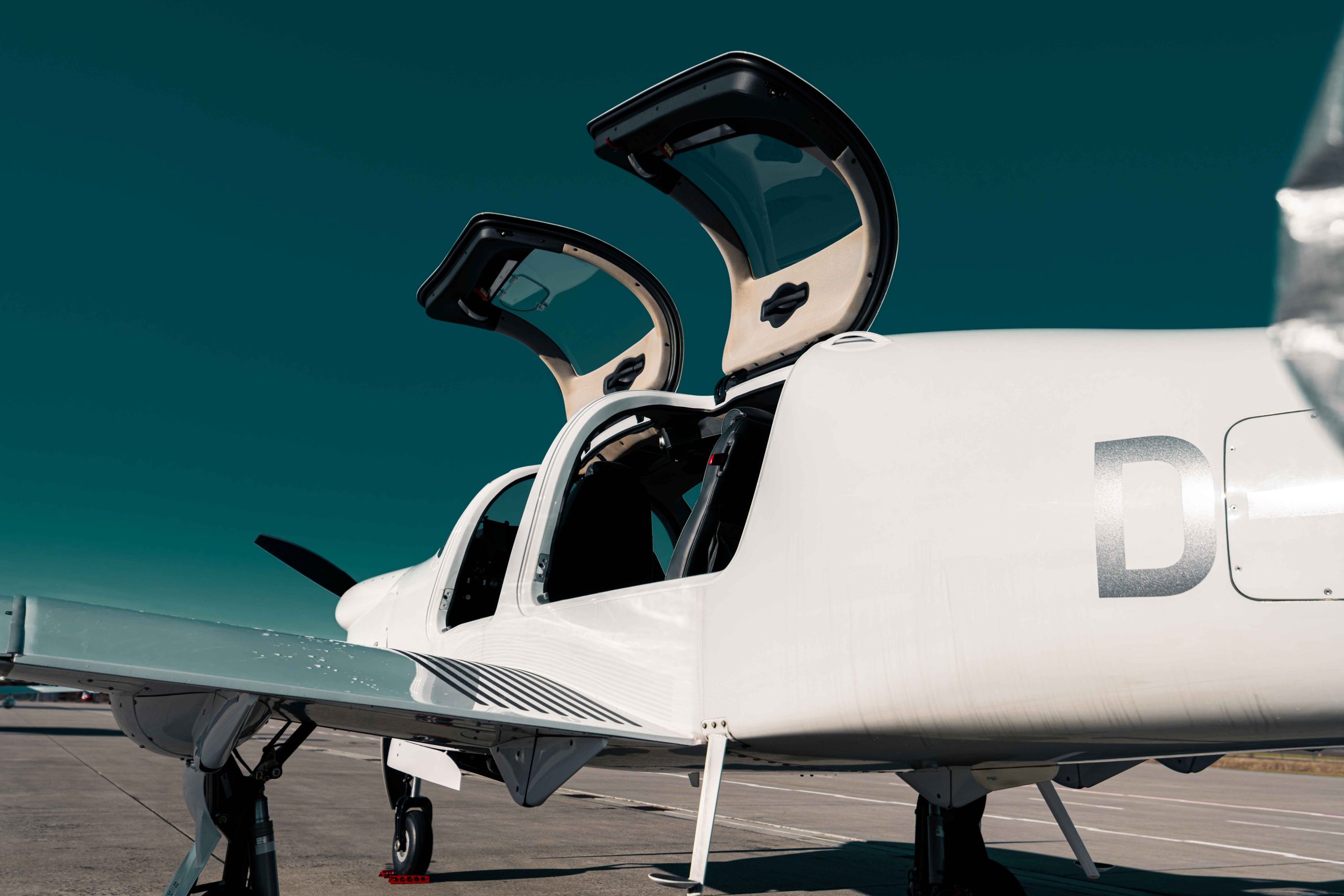 Diamond DA50 RG einmotoriges Reiseflugzeug auf dem Vorfeld mit geöffneten Cockpittüren – moderner 5-Sitzer für komfortable Geschäfts- und Privatflüge.