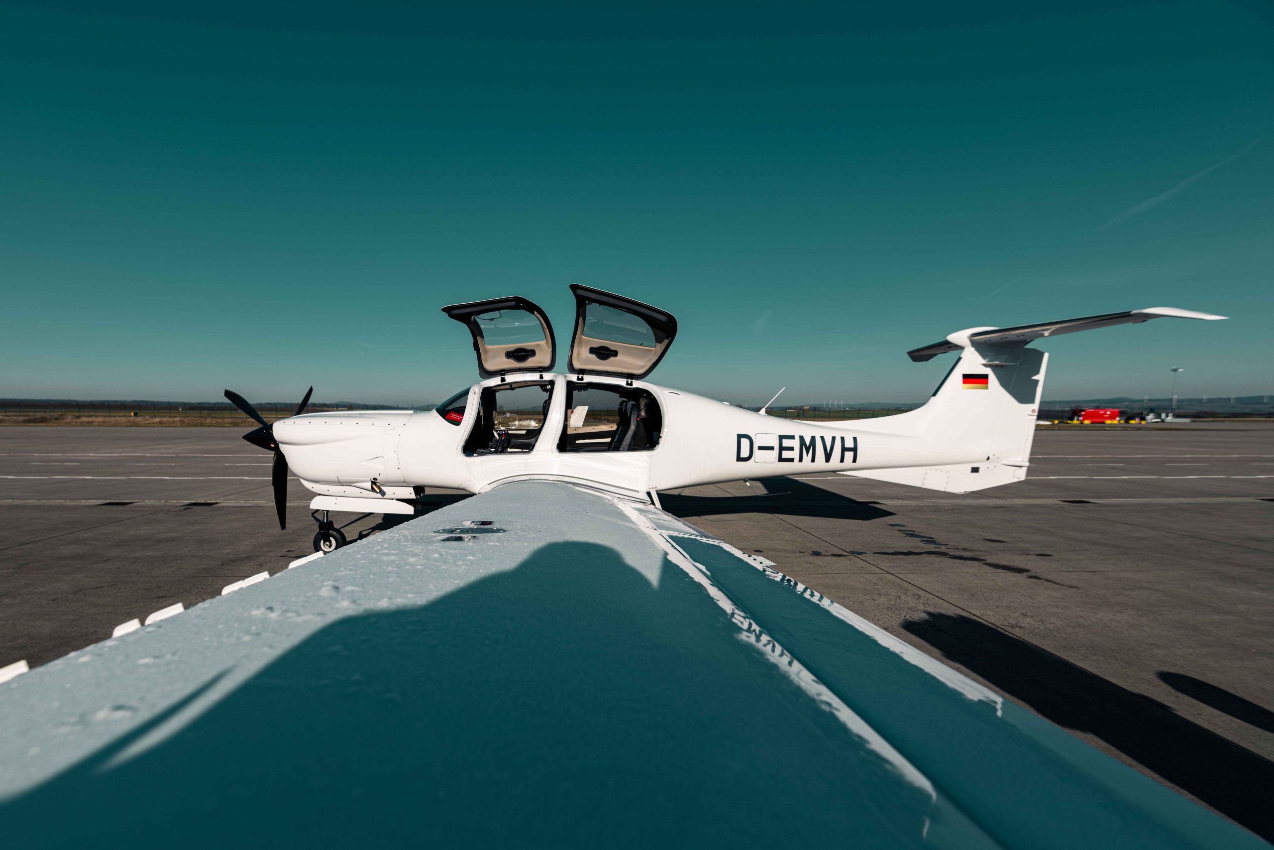 Diamond DA50 RG einmotoriges Reiseflugzeug auf dem Vorfeld mit geöffneten Cockpittüren – moderner 5-Sitzer für komfortable Geschäfts- und Privatflüge.